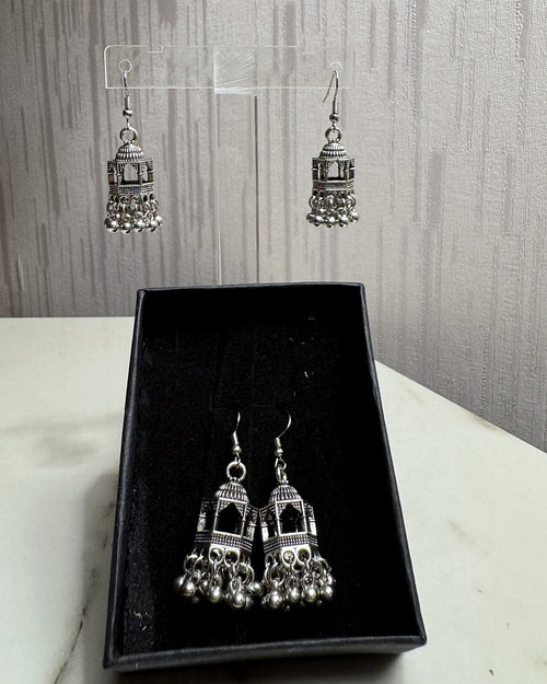 Jharokha oxidised silver jhumka earrings on an acrylic stand and in a black gift box