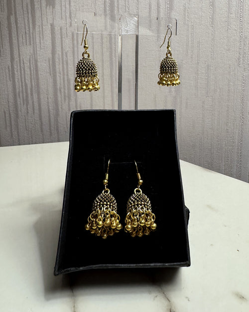 Zarreen antique gold jaali jhumka earrings on an acrylic stand and in a black gift box