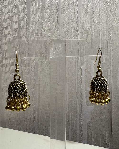 Close-up of Zarreen antique gold jhumka showing the jaali dome and ghungroo bead fringe
