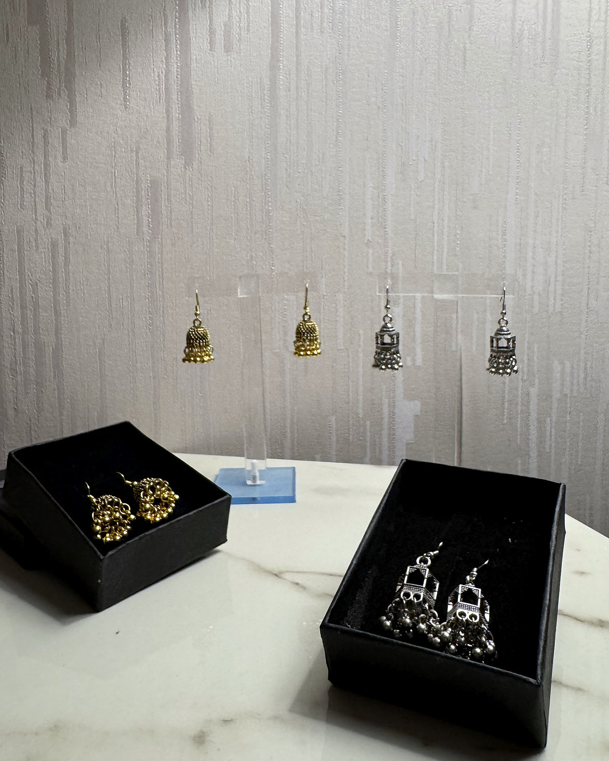 Zulal pack of 2: Zarreen antique gold jhumka and Jharokha oxidised silver jhumka in black gift boxes